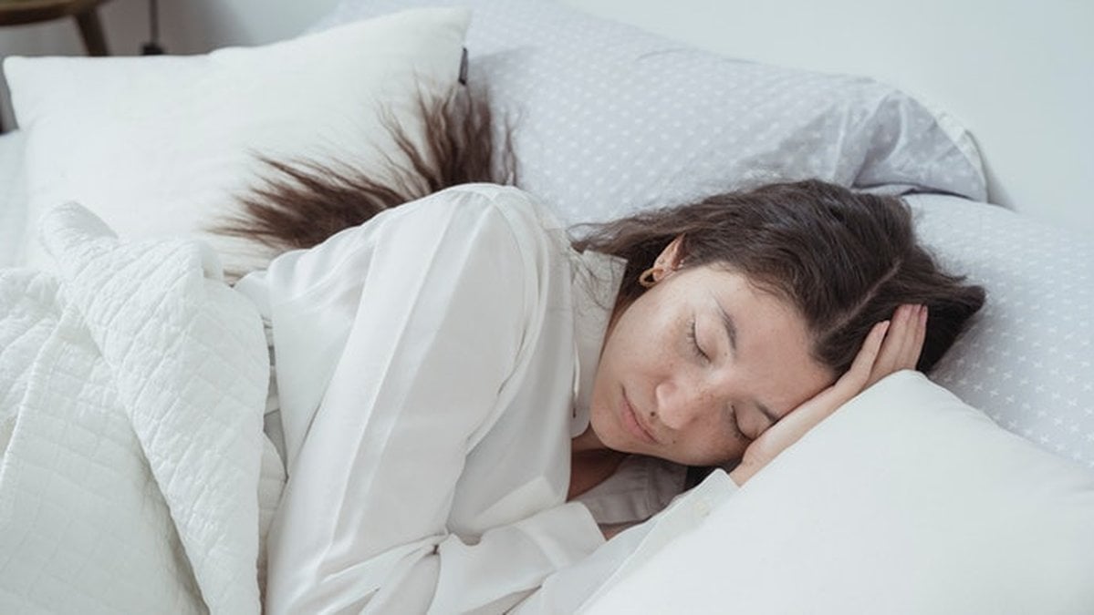 Kvinna-sover-i-en-säng